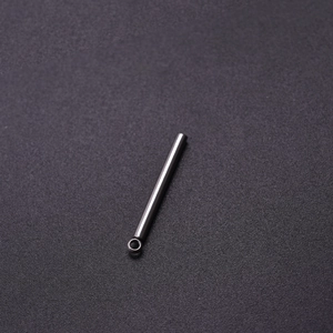 Close-up of polished silver cylindrical stainless steel pendant with small loop connector