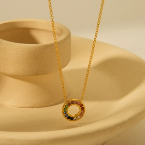 18K gold stainless steel necklace with round rainbow zircon pendant on ceramic display