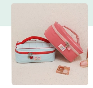 Detail of pink and blue quilted cosmetic bags with heart and flower metal zippers