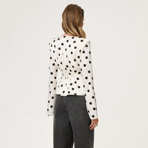 Polka dot long sleeve wrap top with waist tie and ruffle hem shown from the back view