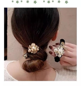Detail of luxury pearl and rhinestone hair tie on an elegant bun hairstyle for women