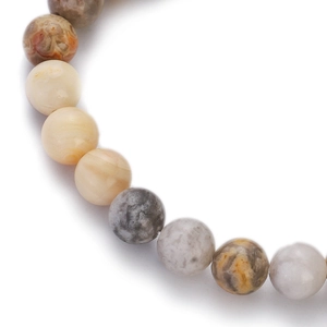 Macro shot of natural agate stone beads with beige and grey textures on white background