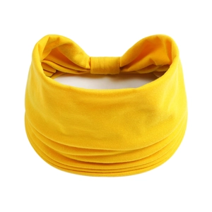 Dettaglio fascia per capelli yoga gialla con nodo centrale e morbida maglia elasticizzata