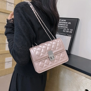 Detail of pink quilted chain bag featuring elegant diamond pattern and metal clasp