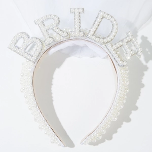 Detail of white pearl headband with BRIDE lettering and multi-layer wedding veil