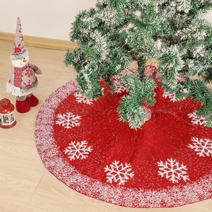 Red knitted Christmas tree skirt with white snowflake patterns and plush faux fur edge