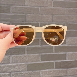 Detail of beige folding children's sunglasses with UV400 lenses and CE safety mark