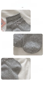 Detail view of grey knit socks with white bows and hollow mesh texture on heels and toes