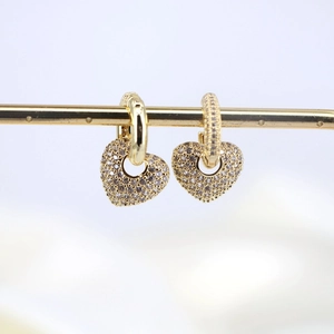 Detailed close-up of golden heart earrings with micro-pave cubic zirconia crystals