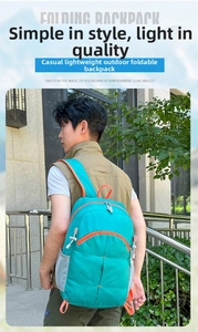 Outdoor view of a lightweight foldable lake blue hiking backpack with orange trim on a model