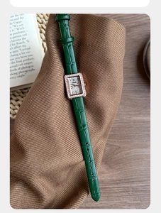 Dettaglio del cinturino in pelle coccodrillo verde e cassa rettangolare strass oro rosa