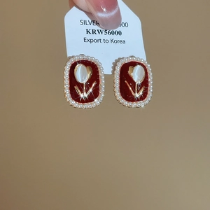 Detail of vintage tulip earrings with red enamel and surrounding white pearls