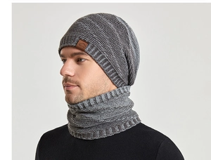 Détail d'un ensemble bonnet et écharpe en grosse maille grise avec écusson en cuir