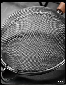Close-up of fine stainless steel mesh strainer with durable wooden handle for kitchen use