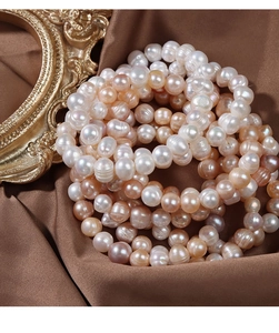Lustrous multi-color natural freshwater pearls displayed on elegant brown silk fabric