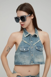 Macro detail of oversized sunglasses with crystal embellishments on chic denim outfit