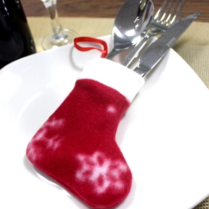 Christmas stocking shaped cutlery holder on white plate with silver utensils