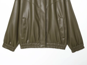 Detail of dark green PU pilot jacket showing elastic hem and synthetic leather texture