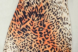Macro shot of high-quality leopard print fabric with orange and black animal patterns