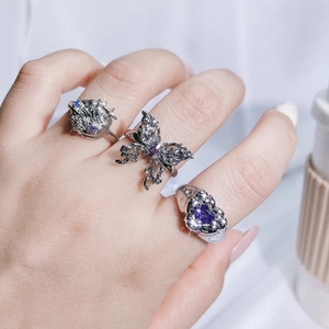Three-piece silver butterfly and heart rings set with sparkling purple gemstones