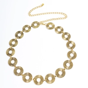 Close-up of vintage gold metal waist chain with sunburst texture and hollow circular links