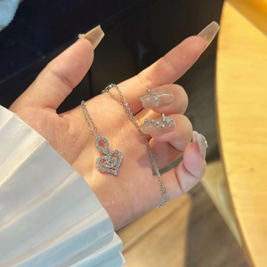 Elegant silver heart pendant necklace with shimmering crystals held in hand