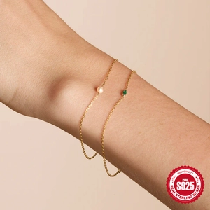 Close-up of S925 sterling silver gold plated bracelet with green zircon and pearl detail