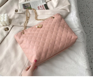 Pink quilted tote bag detail with gold crown pearl pendant and metal chain strap
