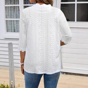 Detail of white hollow lace embroidery and crochet texture on a bohemian cardigan