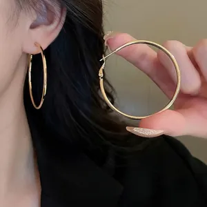 Classic minimalist large gold geometric hoop earrings for women with a sleek metal finish