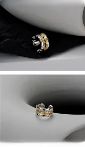 Dettaglio dell'anello aperto bicolore argento e oro con trama organica irregolare