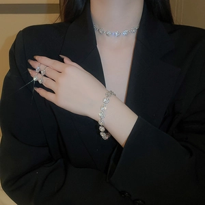 Detail of silver flower jewelry set with sparkling rhinestones worn on black blazer