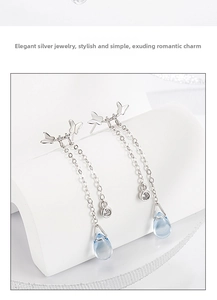Detail of silver butterfly tassel earrings with blue water-drop pendants and zircon
