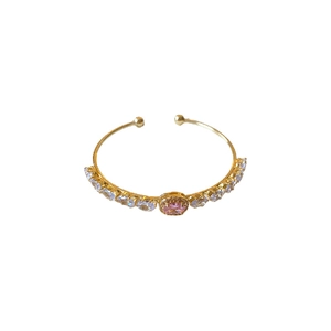 Elegant gold open bangle with oval pink gemstone and sparkling zircon accents