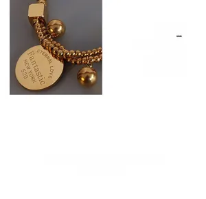 Vue macro détaillée du bracelet à double rangée de perles dorées avec charmes ronds gravés