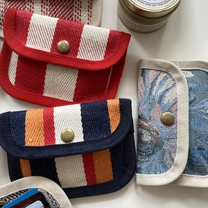 Detail of assorted fabric coin purses with diverse stripe and floral patterns and metal snaps