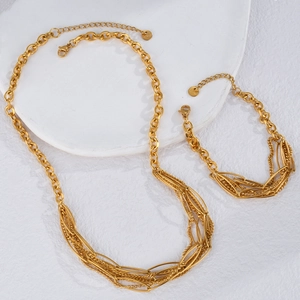 Close-up of gold layered chain necklace and bracelet set with S.Steel engraving