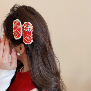 Detail of red Chinese New Year hair clips with gold embroidery for festive styling