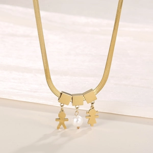 Close-up of golden flat snake chain necklace with boy, girl and pearl charms