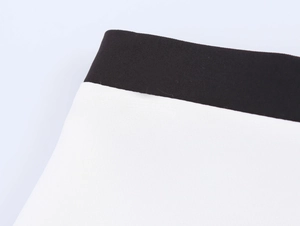 Détail des coutures contrastées noir et blanc et de la texture du tissu de costume