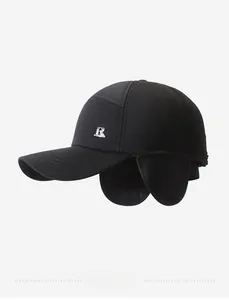 Close-up of winter baseball cap with earflaps and silver metal R logo on black fabric