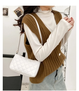 Close-up of white quilted pattern on a shoulder bag with elegant cross-stitch detail