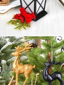 Detail of red bow decoration and gold reindeer ornaments on a Christmas tree
