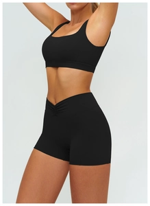 Close-up of black sports bra and high-waisted shorts with V-shaped crossover waist detail