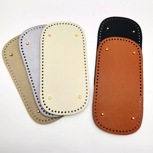 Macro detail of oval PU leather bag bases with metallic studs and pre-punched holes