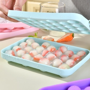 Blue silicone 25-cell round ice cube mold with lid showing fresh strawberry ice spheres