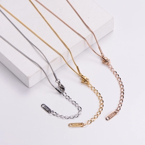 Détail macro de pendentifs cœur 18KGP tricolores avec texture de chaîne serpent lisse
