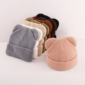 Close-up of ribbed knit texture on kids winter hats featuring cute 3D bear ears detail