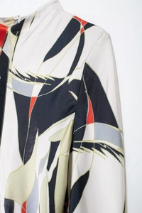 Detailed macro view of elegant satin shirt dress featuring bold abstract geometric patterns