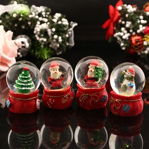 Set of four mini Christmas crystal snow globes with red resin gift bag bases